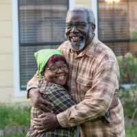 An older African American couple hugging. An older African American couple hugging.