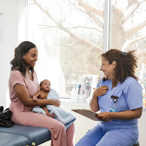 A woman and her infant child at the doctor. A woman and her infant child at the doctor.