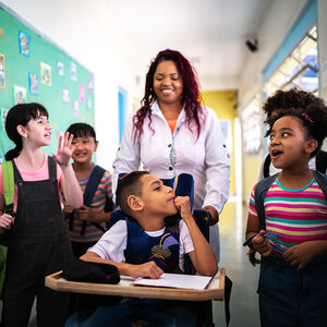 A group of students and their teacher in a school hallway.