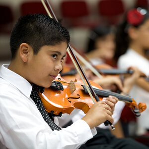 A young boy plays the violin.