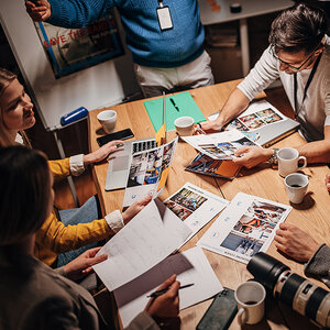 Journalists comparing notes around a table. Journalists comparing notes around a table.