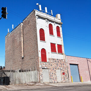 “A boarded up commercial building on a city street.