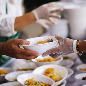 A bowl of food is served at a soup kitchen. A bowl of food is served at a soup kitchen.