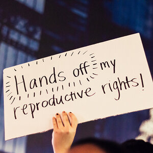 A protester holds a sign at a rally. A protester holds a sign at a rally.