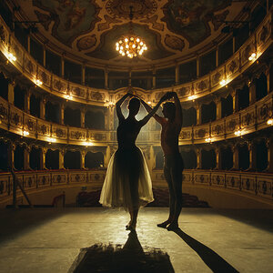 The silhouette of two dancers standing in the center of a stage.