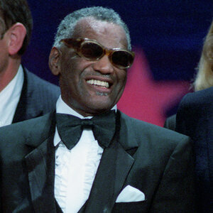 An African American man wearing sunglasses and a tuxedo smiles for the camera - a photo of Ray Charles. An African American man wearing sunglasses and a tuxedo smiles for the camera - a photo of Ray Charles.