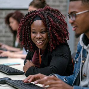 An African American woman and man sit in front of a computer. An African American woman and man sit in front of a computer.