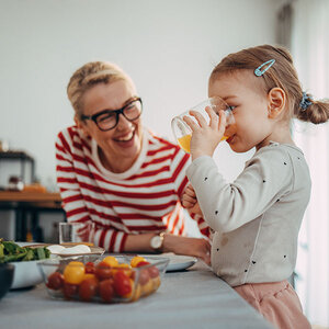 A child and her mother having breakfast. A child and her mother having breakfast.