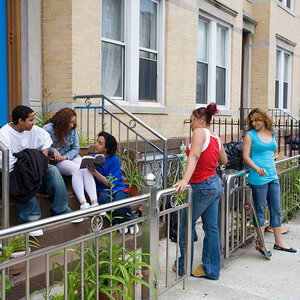 A group of teens sitting outside a home in New York City. A group of teens sitting outside a home in New York City.