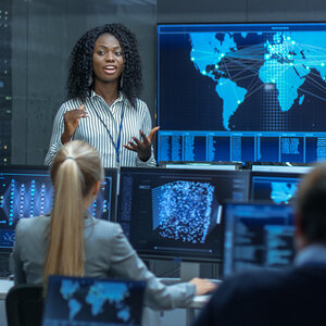 A person presenting data to a group of professionals.