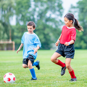 Children in red and blue shirts playing soccer. Children in red and blue shirts playing soccer.