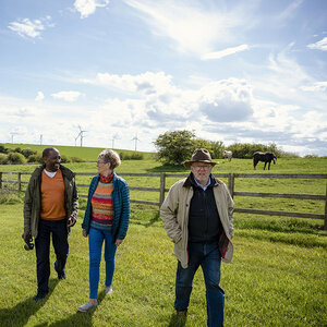 Three people walking through the countryside. Three people walking through the countryside.