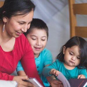 A teacher an two young students in a daycare.
