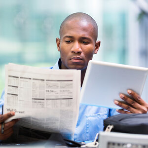 A man catching up on digital and print news. A man catching up on digital and print news.