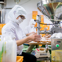 A worker in a food production facility. A worker in a food production facility.