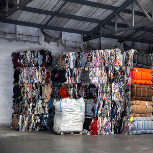 The interior of a warehouse with pallets of used textiles stacked to the roof. The interior of a warehouse with pallets of used textiles stacked to the roof.