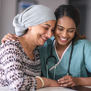 A cancer patient is comforted by her female doctor.