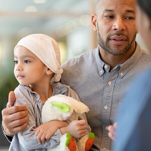 A child with her father at a doctor's appointment.