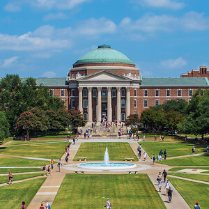 A copper-domed Greek revival college building in a parklike setting surrounded by trees. A copper-domed Greek revival college building in a parklike setting surrounded by trees.