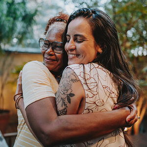 Two women hug. Two women hug.