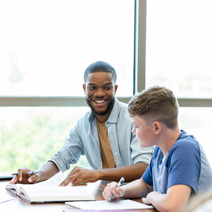A college student mentoring an elementary student.