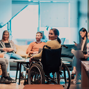 A woman in a wheelchair attends a group meeting. A woman in a wheelchair attends a group meeting.