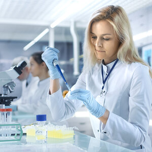 A female scientist conducts a lab experiment.