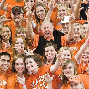 An older man surrounded by college students wearing orange t-shirts – a group photo with T. Boone Pickens at center. An older man surrounded by college students wearing orange t-shirts – a group photo with T. Boone Pickens at center.
