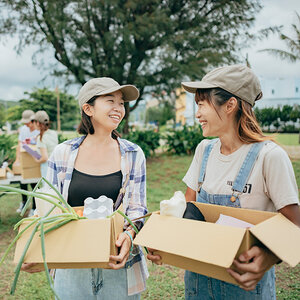 Two women with donation boxes for sustainable community building. Two women with donation boxes for sustainable community building.