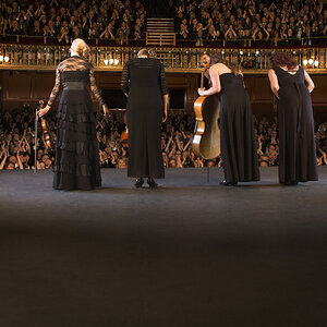 Performers bowing for a crowd on stage. Performers bowing for a crowd on stage.