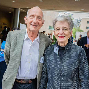 An elderly husband and wife at a public event smile for the camera – an image of Ernest and Evelyn Rady.
