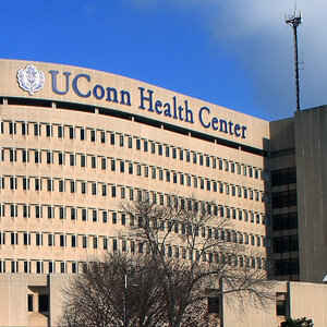 The façade of a large modern hospital building with a sign that reads UConn Health Center.