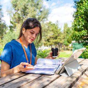 A nursing student studying outdoors. A nursing student studying outdoors.
