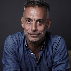 A headshot of a man with salt and pepper facial hair—a photo of Joe Mantello. A headshot of a man with salt and pepper facial hair—a photo of Joe Mantello.