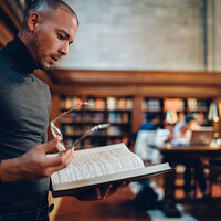 A man reading in a library. A man reading in a library.