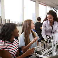 A STEM class with girls talking to their teacher. A STEM class with girls talking to their teacher.