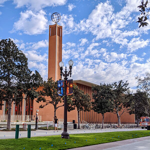 A modern college campus building surrounded by trees.