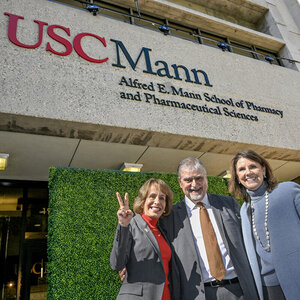 USC President Carol L. Folt, Dean Vassilios Papadopoulos and USC Trustee Chair Suzanne Nora Johnson, from left, pause in front of the building sporting the school’s new name. 