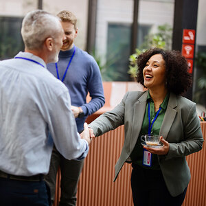 A man and woman shake hands at a conference.
