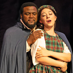 Two opera singers, a man and woman, performing in costume.
