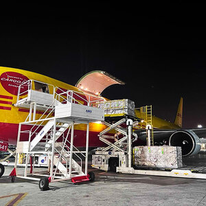 Cargo is being loaded into an airplane at night.