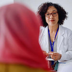 A muslim woman wearing a hijab meets with her doctor to discuss cervical cancer. A muslim woman wearing a hijab meets with her doctor to discuss cervical cancer.
