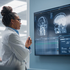 A researcher reviewing brain scans. A researcher reviewing brain scans.